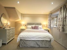 A bedroom with a bed and dresser at The Coach House in Burford