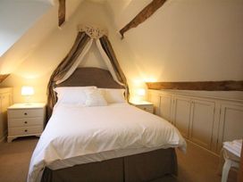 A bedroom with a bed and bedside tables at The Coach House in Burford