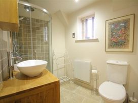 A bathroom with a shower, sink, and toilet at The Coach House in Burford