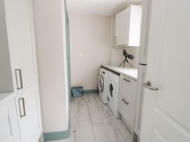 A laundry room with a washing machine and dryer at 2 Lon Y Dryw Trearddur Bay