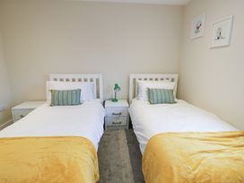 A bedroom with two single beds and a lamp at 2 Lon Y Dryw Trearddur Bay