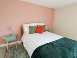 A bedroom with a bed and nightstand at 2 Lon Y Dryw in Trearddur Bay