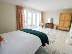 A bedroom with bed and sliding doors at 2 Lon Y Dryw in Trearddur Bay