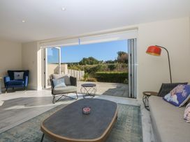A living room with a sliding door leading to outdoor space at 2 Lon Y Dryw in Trearddur Bay