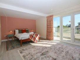 A bedroom with a bed and sliding doors at 2 Lon Y Dryw Trearddur Bay