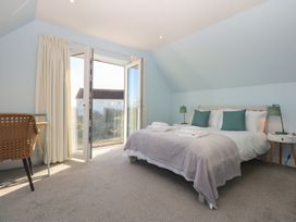 A bedroom with a bed and a table at 2 Lon Y Dryw in Trearddur Bay