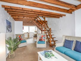 A living room with a staircase and seating area at Cilan - 2 Ty'n Don in Llanengan near Abersoch