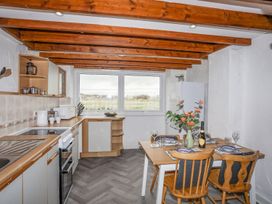 A kitchen with table and chairs at Cilan - 2 Ty'n Don in Llanengan near Abersoch