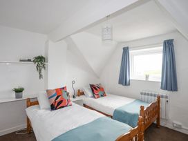 A bedroom with two beds and a shelf at Cilan - 2 Ty'n Don in Llanengan near Abersoch