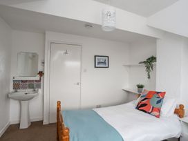 A bedroom with a bed and sink at Cilan - 2 Ty'n Don in Llanengan near Abersoch