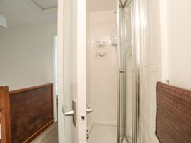 A bathroom with a shower and towel rack at Cilan - 2 Ty'n Don in Llanengan near Abersoch