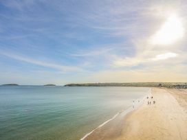 A beach with people walking along the shore at Cilan - 2 Ty'n Don Llanengan near Abersoch