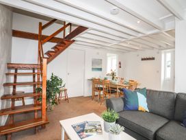 A living room with a staircase and dining area at Rhiw - 1 Ty'n Don Abersoch