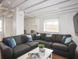 A living room with a sofa and table at Rhiw - 1 Ty'n Don Abersoch