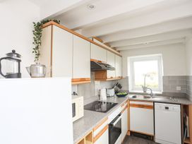 A kitchen with appliances and a window at Rhiw - 1 Ty'n Don in Abersoch