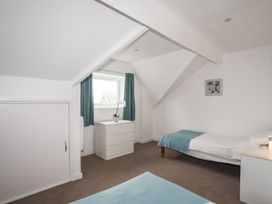 A bedroom with a bed and a drawer at Rhiw - 1 Ty'n Don in Abersoch