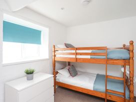 A bedroom with a bunk bed and a dresser at Rhiw - 1 Ty'n Don, Abersoch