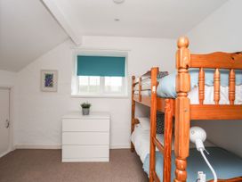 A bedroom with a bunk bed and dresser at Rhiw - 1 Ty'n Don, Abersoch
