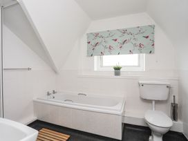 A bathroom featuring a bath tub and a toilet at Rhiw - 1 Ty'n Don in Abersoch