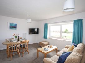 A living room with a dining table and chairs at Oer - 8 Ty'n Don in Llanengan near Abersoch