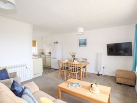 A living room with a dining area and kitchen appliances at Oer - 8 Ty'n Don Llanengan near Abersoch