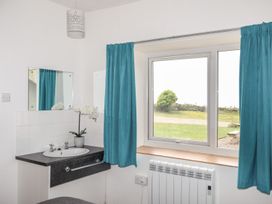 A bathroom with a sink and mirror at Oer - 8 Ty'n Don Llanengan near Abersoch