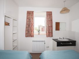 A bedroom with two beds and a sink at Oer - 8 Ty'n Don Llanengan near Abersoch