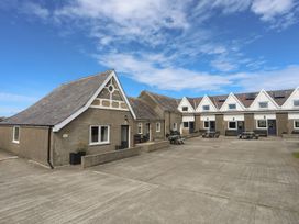 An outdoor area with buildings and benches at Ysgo - 6 Ty'n Don Abersoch
