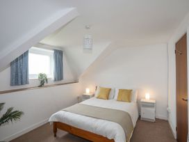 A bedroom with a bed and curtains at Ysgo - 6 Ty'n Don in Abersoch
