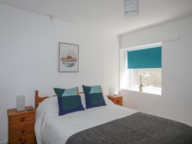 A bedroom with a bed and a nightstand at Ysgo - 6 Ty'n Don in Abersoch