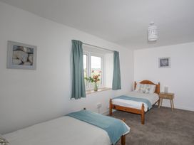 A bedroom with two beds and a window at Ysgo - 6 Ty'n Don Abersoch