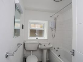 A bathroom with a mirror, toilet, sink, and bathtub at Ysgo - 6 Ty'n Don Abersoch