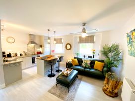 A living room with a sofa and kitchen in Meadfoot Bay Apartment at Hesketh Crescent Torquay