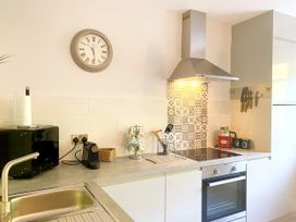 A kitchen with a stove, sink, and various appliances at Meadfoot Bay Apartment at Hesketh Crescent, Torquay