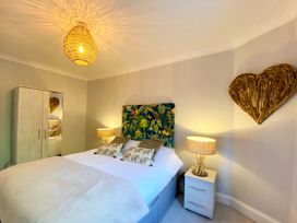A bedroom with a bed and wardrobe at Meadfoot Bay Apartment at Hesketh Crescent in Torquay