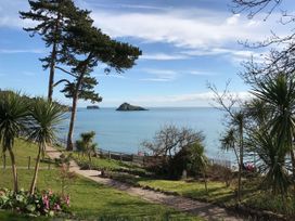 A garden with a path leading to the ocean at Meadfoot Bay Apartment at Hesketh Crescent Torquay