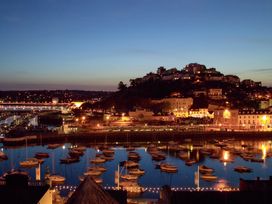 A coastal scene with boats on water and illuminated buildings at Meadfoot Bay Apartment at Hesketh Crescent Torquay
