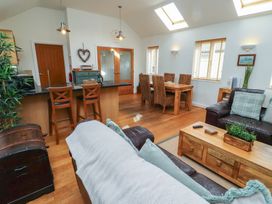 An open plan living area with a sofa and wooden dining table at Hideaway Cottage No 1 Seahouses