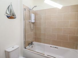 A bathroom with a bathtub and shower at Hideaway Cottage No 1 Seahouses