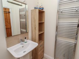 A bathroom with a sink and a mirror at Hideaway Cottage No 1 Seahouses