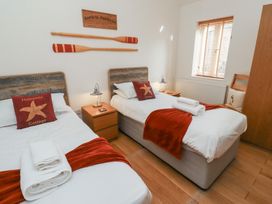 A bedroom with two beds and a nightstand at Hideaway Cottage No 1 Seahouses