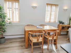 A dining room with a wooden table and chairs at Hideaway Cottage No 1 Seahouses