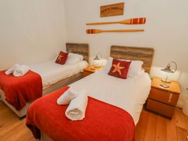 A bedroom with two beds and wooden decorations at Hideaway Cottage No 1 Seahouses