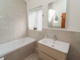 A bathroom with a bathtub and sink at Hideaway Cottage No 1 in Seahouses