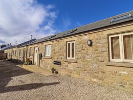 A stone building with windows and a sign at Hideaway Cottage No 1 Seahouses