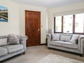 A living room with two sofas and a door at Dolly Blue Backbarrow near Newby Bridge