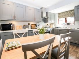 A kitchen with a table and chairs at Dolly Blue in Backbarrow near Newby Bridge