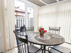 A table with chairs and a flower vase at Dolly Blue in Backbarrow near Newby Bridge