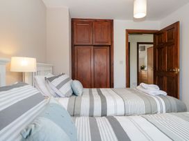 A bedroom with two beds and a wardrobe at Dolly Blue Backbarrow near Newby Bridge