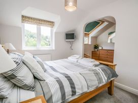 A bedroom with a bed and television at Dolly Blue in Backbarrow near Newby Bridge